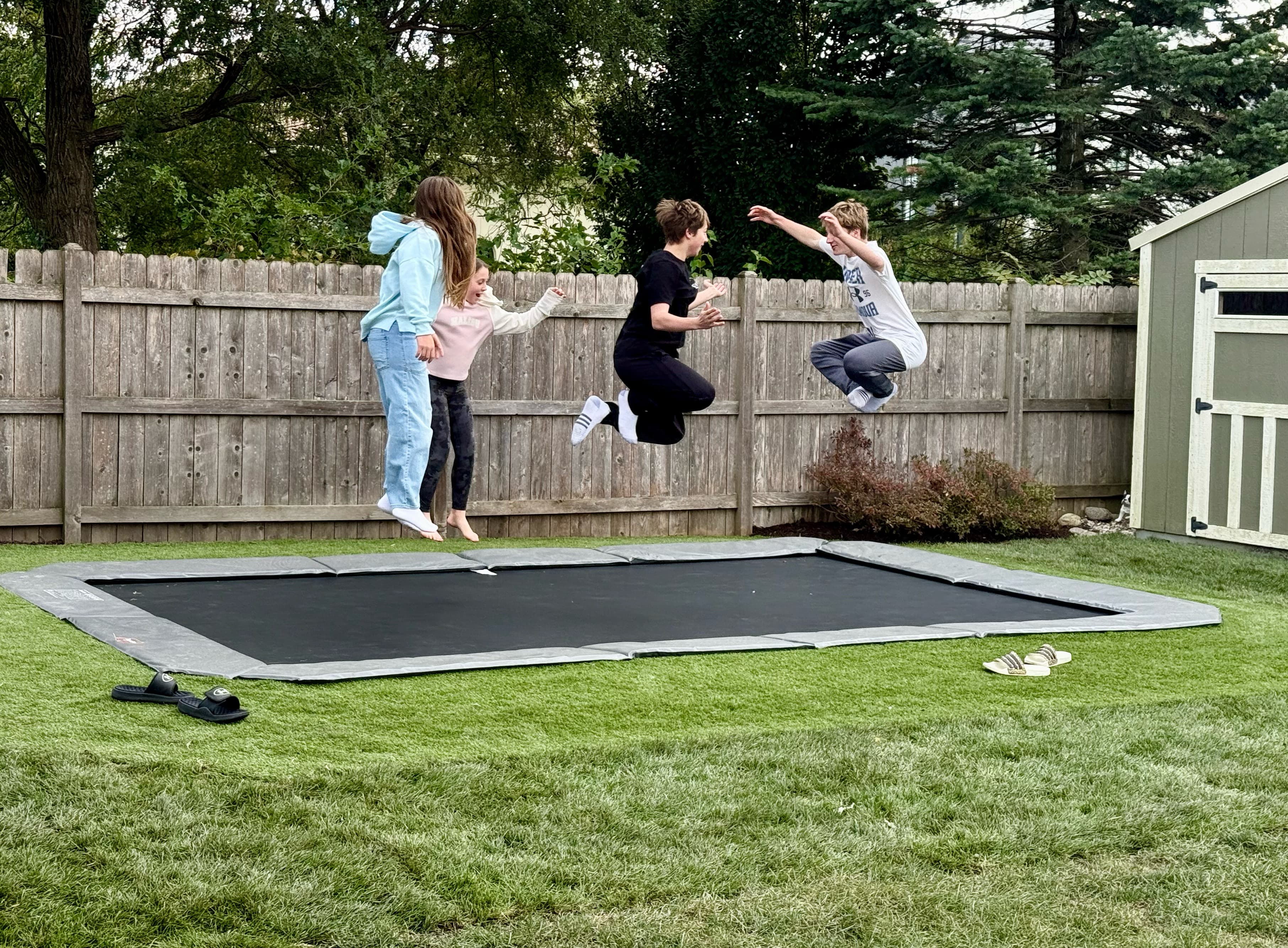 Kids jumping on in-ground trampoline installed by River Fall